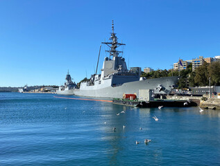 Military ships in the port of coastal city. Navy boats moored to a quay. Battleship in port. A...