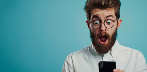 Shocking News: Surprised man with glasses stares at his smartphone, mouth open in amazement - obrazy, fototapety, plakaty