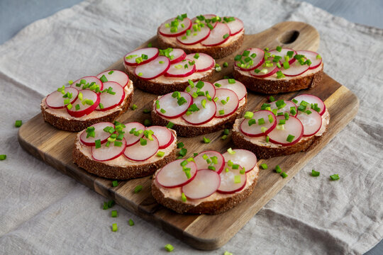 Homemade Lemon Radish Tartine on a wooden board, side view.