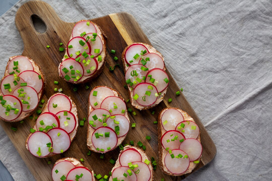 Homemade Lemon Radish Tartine on a wooden board, top view. Copy space.