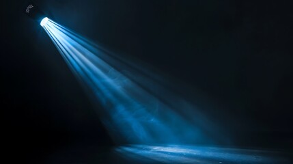 Blue spotlight on the stage. Dark background with a single spotlight shining down.