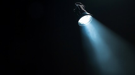 Bright stage spotlight with a narrow beam of light in the dark.