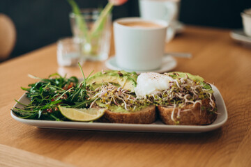Bread Toast and Poached Egg with Green Salad and Avocado. Breakfast concept. Morning time. Avocado egg sandwich with whole grain bread