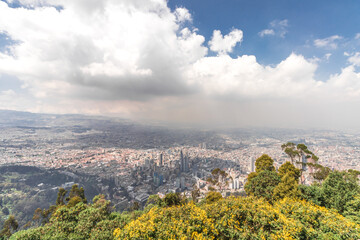 Landscape of the city of Bogota in Colombia from Monserrate hill on a sunny summer day with clouds and some vegetation