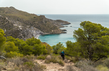 Landscape with a man hiking on cliffs, with the sea on background