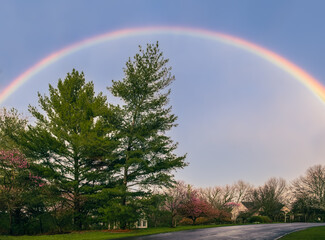 Beautiful view of  rainbow over suburban Midwestern street in early spring after rain