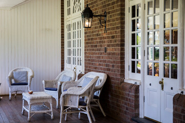 outdoor white rattan seating in the patio of a brick house