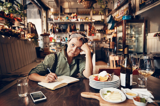 Senior waitress doing expenses at a restaurant table