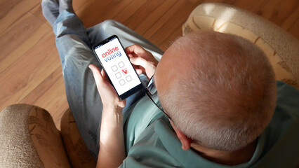 A man voting online using a smartphone in the hands