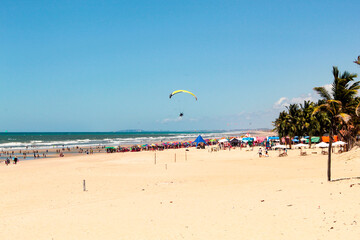 Fortaleza, Ceará, Brazil, September 2022. Umbrellas, palm trees and paragliding at Future beach,...