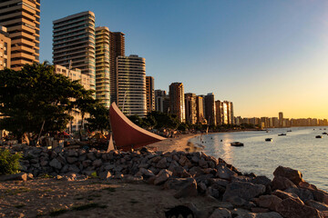 View of the buildings on the edge of Iracema beach, Fortaleza, Ceará, northeastern Brazil, with the sunset light reflecting on the facades - obrazy, fototapety, plakaty