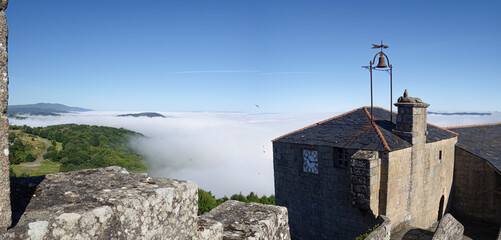 Vista panorámica de nubes blancas en el Pueblo Bonito de España, Castro Caldelas, Orense, desde el castillo con el campanario al fondo, en España ,verano de 2021