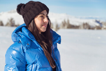 Beautiful woman with warm blue jacketstanding  in the winter mountain 