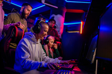 Fototapeta na wymiar Bald female gamer in cyber club with neon lights playing a video game