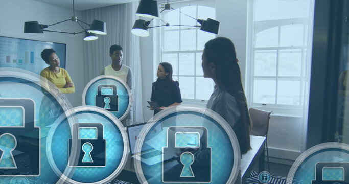 Image of padlock in circles over diverse female coworkers discussing reports in office - Powered by Adobe