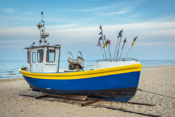 Naklejka na ściany i meble Fishing boat on Baltic Sea beach in Karlikowo District in Sopot city, Poland