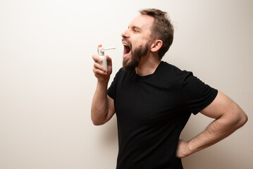 Throat spray used by middle aged bearded hipster man to cure sore throat