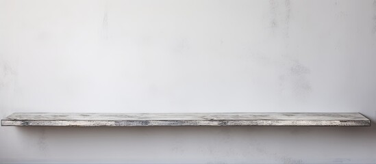 A rectangular wooden shelf, with various dishware displayed on it, contrasts against a white wall in a monochrome still life photography composition