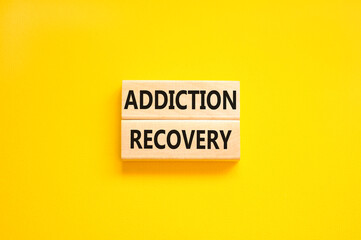 Addiction recovery symbol. Concept words Addiction recovery on beautiful wooden blocks. Beautiful yellow table yellow background. Psychology addiction recovery concept. Copy space.