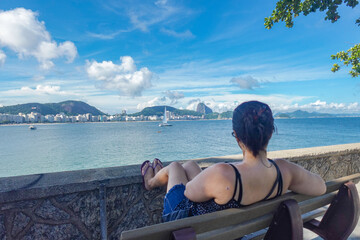 Turista apreciando un día soleado toda la vista de la playa de Copacabana en Rio de Janeiro - obrazy, fototapety, plakaty