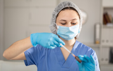 Fototapeta na wymiar Nurse fills a syringe with injection solution