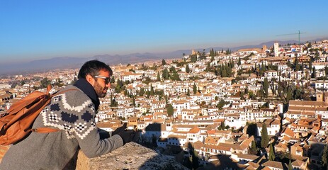 Joven turista contemplando la ciudad de Granada desde la Alhambra.  - obrazy, fototapety, plakaty