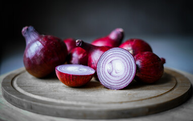Purple onions on the wooden board. Close up. 
