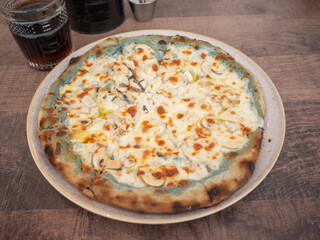 a whole pizza with a lot of cheese on the table of the cafe in kharkiv city