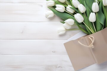 Fresh white tulips bunch near paper shopping bag on wooden background.