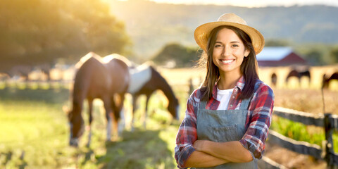 Frau im Vordergrund im Hintergrund Pferde auf einer Wiese  - obrazy, fototapety, plakaty