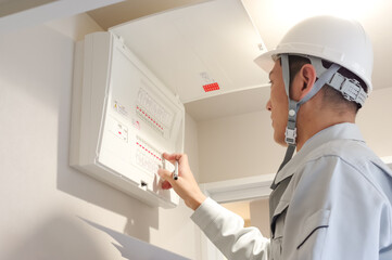 配電盤の検査をする作業服の男性