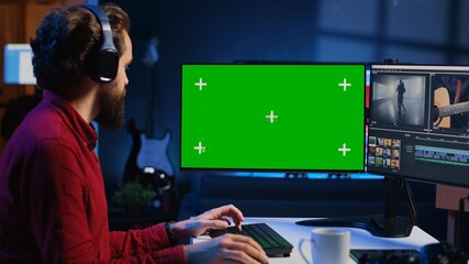Videographer using professional software on chroma key PC to create visual effects for video projects. Expert using post production techniques to edit raw clips footage on isolated screen monitor