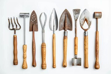 A collection of well-used garden tools, such as a fork, trowel, and spade, laid out meticulously on a white surface