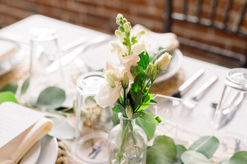 An elegant dining table decorated with fresh flowers and greenery