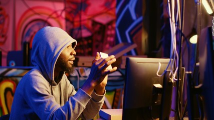 Hacker holding SSD device with valuable information after doing data breaches and financial theft....