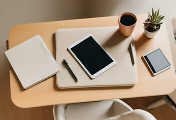 Top view of a minimalist desk with a tablet and pens on it