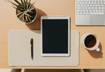 Top view of a minimalist desk with a tablet and pens on it