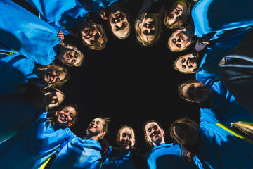 teenage girls in blue uniforms standing in a circle and getting ready for the school match, low...