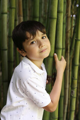 ni&ntilde;o sonriente posando entre bamb&uacute;s