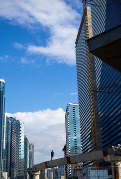 Construction of a high-rise building in Asia. A man among tall buildings. Resort town. Concrete frame. Modern high-rise buildings.