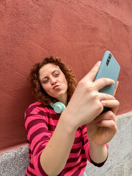 Redhead woman taking a selfie with a kiss face expression