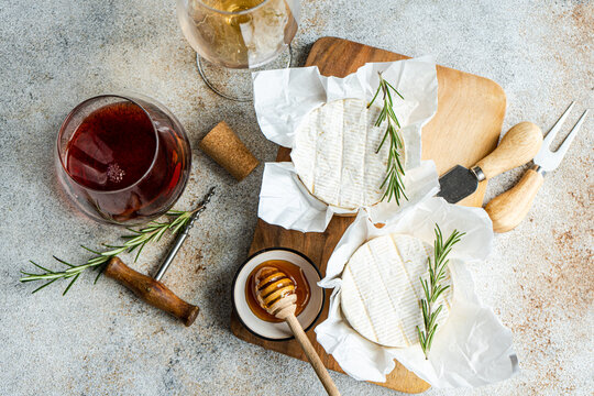 Gourmet Brie cheese with red and white wine on a rustic table