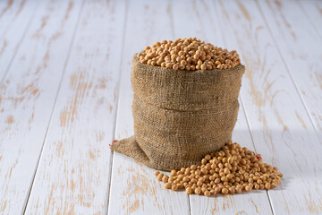 Raw soybeans in sack on a light table, selective focus.