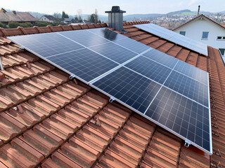 Solar panels on the roof of a house with red tiles