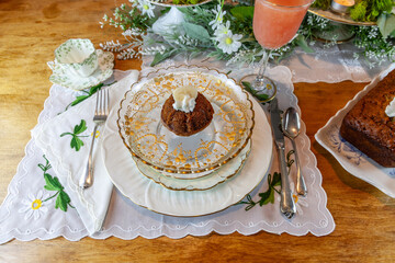 Banana bread with whipped cream served on fine China plates and crystal with gold inlay