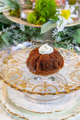 Banana bread with whipped cream served on fine China plates and crystal with gold inlay