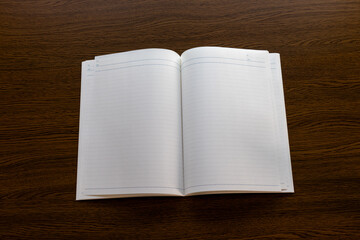 木の机の上に開かれた白地のノート