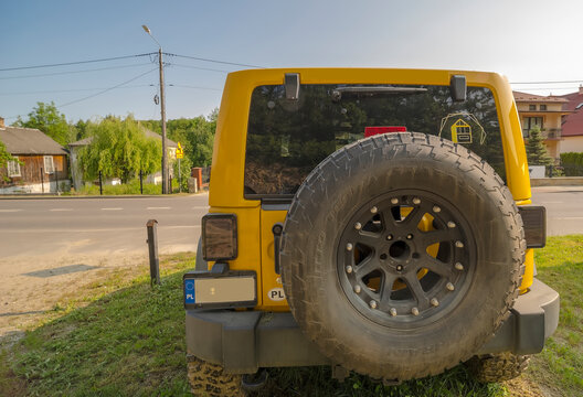 Polska Bałtów 27 maja 2024 o 16:07. Jeep Rubicon na trawie na malutkim wzgórku. Żółty klasyczny (kultowy) amerykański samochód terenowy z kołem zapasowym i dużą oponą terenową.