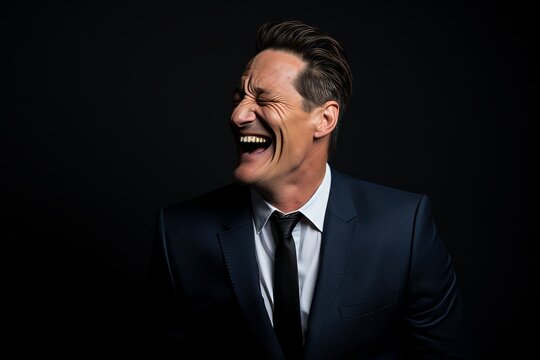 Portrait of a handsome middle-aged man laughing against black background