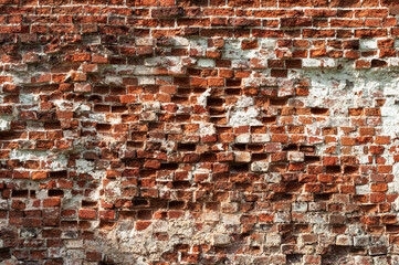 Texture of old damaged red brick wall with remains of lime